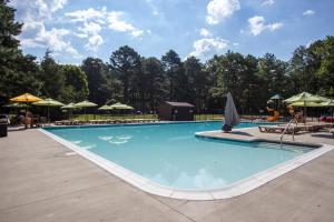 a swimming pool at a resort with umbrellas at Richmond North / Kings Dominion KOA in Doswell