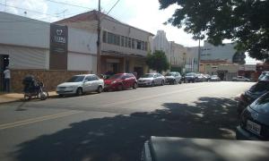 uma fileira de carros estacionados em uma rua da cidade em Shalon Hotel em Uberaba