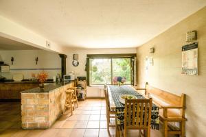a kitchen with a table with chairs and a tableasteryasteryasteryasteryasteryastery at Posada La Charola in Lamadrid