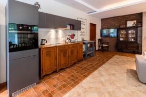 uma cozinha com armários de madeira e piso em azulejo em Apartament Perła Kartuz z sauną em Kartuzy