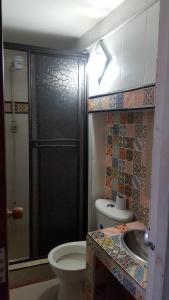 a bathroom with a shower and a toilet and a sink at Hostal Balcony in Popayan
