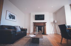 a living room with a couch and a fireplace at Impressive 3 bedroom in Aberdeen