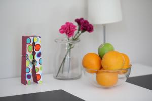 a bowl of oranges on a counter with a vase with flowers at Landvetter House in Landvetter +23 photos