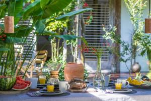 a table topped with plates of fruit and juice at Casa Lola in Trancoso
