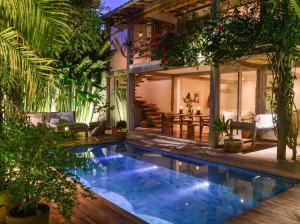 a pool in the backyard of a house with plants at Casa Lola in Trancoso