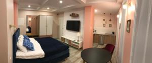 sypialnia z łóżkiem oraz kuchnia z telewizorem w obiekcie Apartament Weyssenhoffa 9 w Bydgoszczy