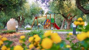 a playground with a slide in a park with trees at Lena Mare in Chrani