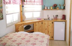 a small kitchen with a table and a microwave at Jordan Valley one room apartment in Menaẖemya