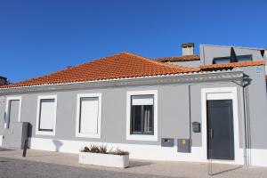 a white building with a black door on a street at Alboi Loft in Aveiro