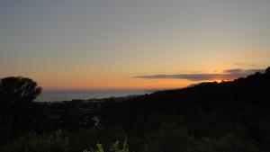 una puesta de sol sobre una colina con el océano en el fondo en Casa Ranita, en Marbella