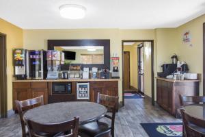 a dining room with a table and a kitchen with a counter at Super 8 by Wyndham Nampa in Nampa