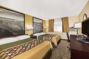 a hotel room with two beds and a desk at Super 8 by Wyndham Nampa in Nampa +20 photos