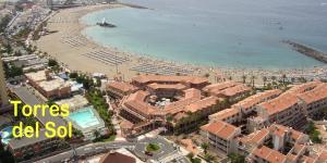 a view of a beach with buildings and the ocean at TORRES DEL SOL to 50 METTERS PLAYA LAS VISTAS Best beach Tenerife in Playa de las Americas