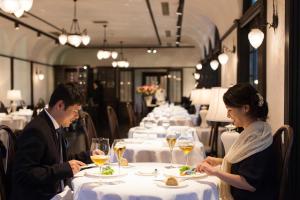 a man and woman sitting at a table in a restaurant at Restaurant & Hotel Traumerei in Hakuba