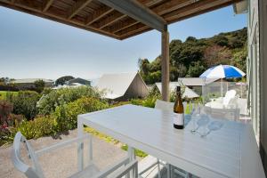 - une table blanche avec deux verres de vin sur la terrasse dans l'établissement Robins Nest, à Russell