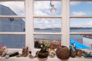 a window with a view of the ocean through it at Palafitos Emilio y Ester in Castro