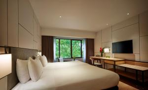 a hotel room with a large bed and a desk at PARKROYAL Penang Resort in Batu Ferringhi