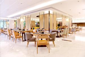 a dining room with tables and chairs in a restaurant at Galaxy minyoun Chengdu Hotel in Chengdu