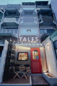 a building with a red door and a sign that reads tales at Tales Khaosan (Cafe & Hostel) in Bangkok