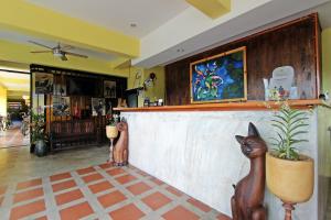 a lobby with a bar with a cat statue at Baan Pordeedin in Chiang Rai