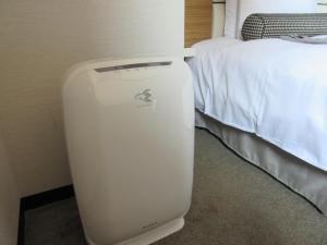 a hotel room with a heater next to a bed at Hotel Trusty Osaka Abeno in Osaka
