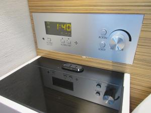 a microwave oven with a clock on top of it at Hotel Trusty Osaka Abeno in Osaka