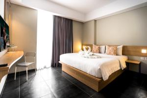 Un pat sau paturi într-o cameră la Maple Hotel Grogol