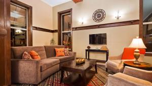 a living room with a couch and a table at Best Western Park Hotel in Warren