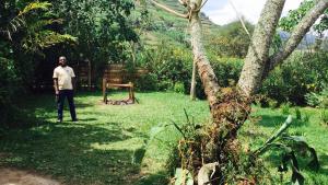 a man standing in a yard next to a tree at Karungi Camp in Rubuguli