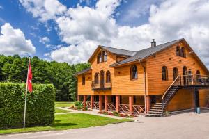 uma grande casa de madeira com uma escada e uma bandeira em Bražuolėje Pas Juozą- ramiam poilsiui em Trakai