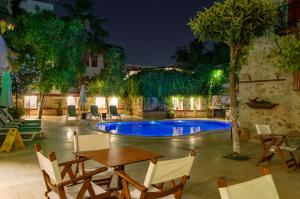 a patio with a table and a pool at night at White Garden Hotel-Adult Only in Antalya