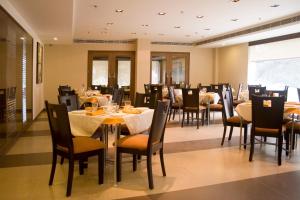 a dining room with tables and chairs in a restaurant at Shervani Nehru Place in New Delhi
