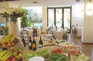 un tavolo ricoperto da molto cibo e bottiglie di vino di Hotel First a Calenzano