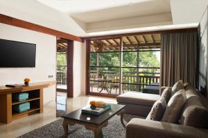 a living room with a couch and a tv at Amnaya Resort Kuta in Kuta