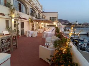 a restaurant with white tables and chairs on a balcony at Hotel Tirreno in Trapani