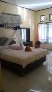 un bambino che giace su un letto in una camera da letto di Bintang Wisata Riung a Riung