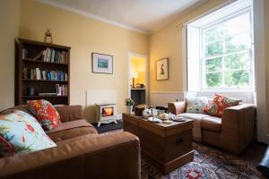 uma sala de estar com dois sofás e uma mesa de centro em Kilmaronock Manse B&B em Drymen