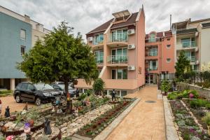 an apartment building with a garden in front of it at Family Hotel Venera in Sveti Vlas