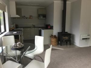 a living room with a table and a stove at Baybell Lodge in Tauranga