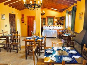 サンティリャーナ・デル・マルにあるPosada La Cabaña De Salmonの木製のテーブルと椅子、テーブルとビュッフェ式のレストランを併設しています。