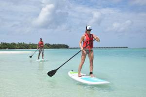 Deux personnes font du paddleboard dans l'océan dans l'établissement Araamu Holidays & Spa, à Dhiffushi