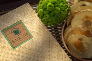 a sign for a guayaquil and a bowl of green fruit at Amnaya Resort Kuta in Kuta