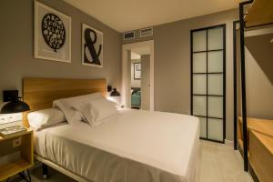 a bedroom with a large white bed and a window at Apartamentos Dubamar in Aguadulce