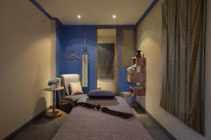 a living room with a chair and a blue wall at Amnaya Resort Kuta in Kuta