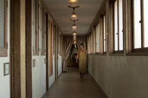 a woman walking down a hallway in a building at Amnaya Resort Kuta in Kuta