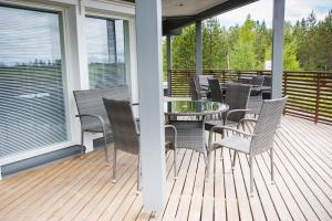 a patio with chairs and a glass table on a deck at Villa APR in Kurikka