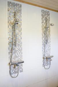 a bathroom with two shower heads on a wall at Villa APR in Kurikka