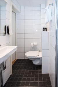 a white bathroom with a toilet and a sink at Kinsarvik Fjordhotel, BW Signature Collection in Kinsarvik