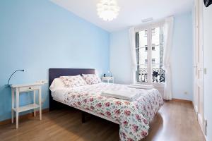 a blue bedroom with a bed and a window at Apartments Barcelona & Home Deco Eixample in Barcelona
