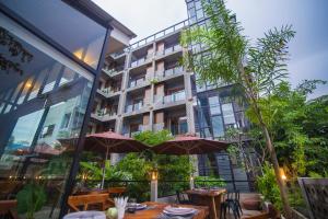 a restaurant with tables and umbrellas in front of a building at Sarina Boutique Hotel in Phnom Penh